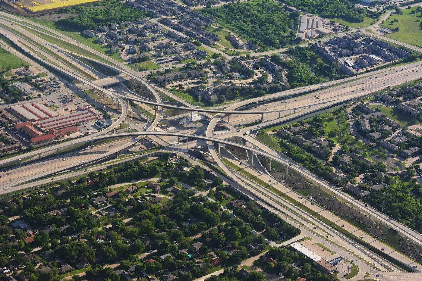 Aerial view of a highway interchange crossing through green rural and suburban land
