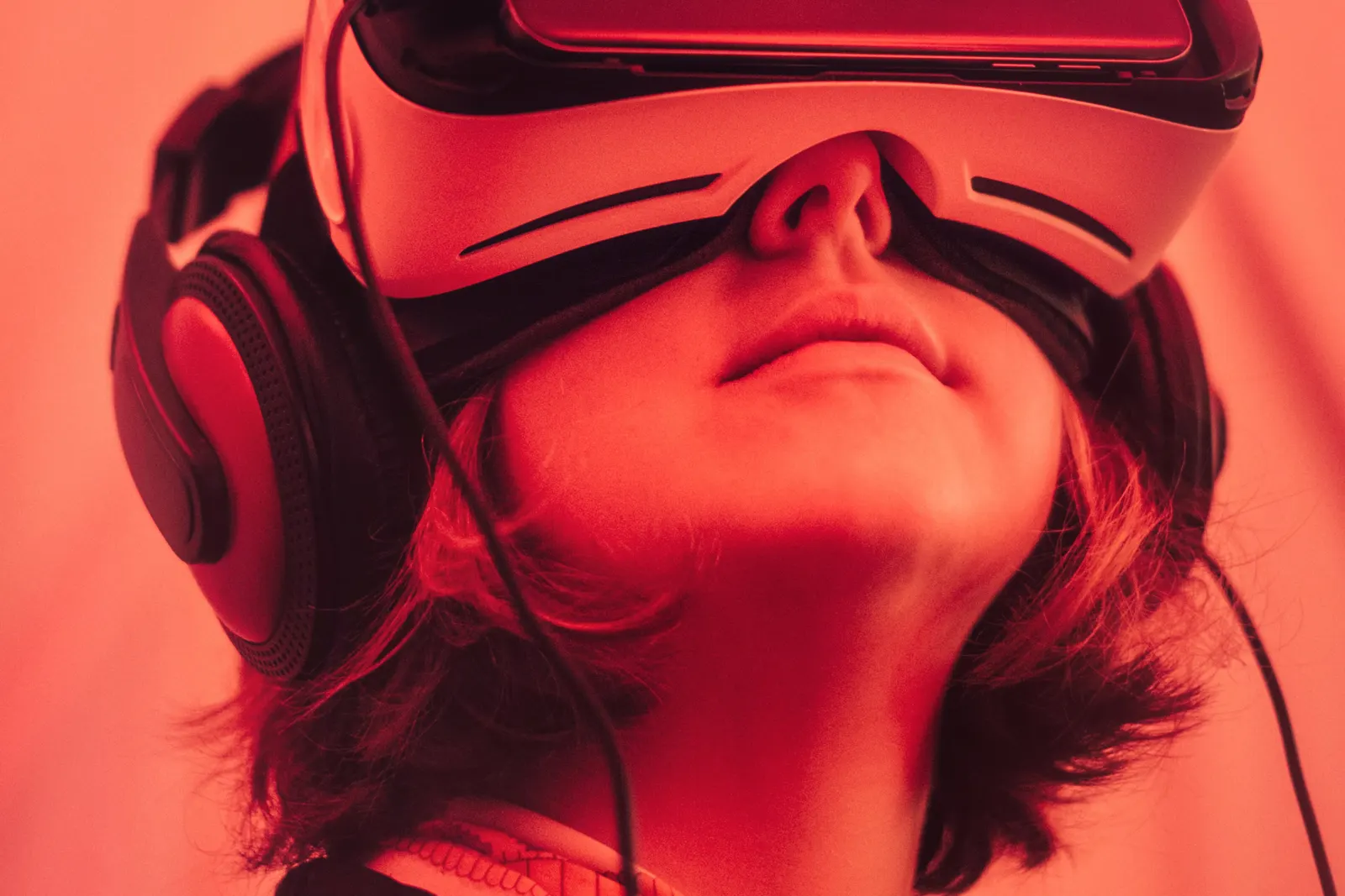 Person wearing a virtual reality headset bathed in red light